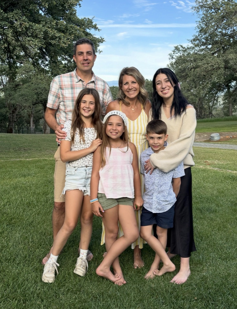 Kara with her husband and four children on the lawn