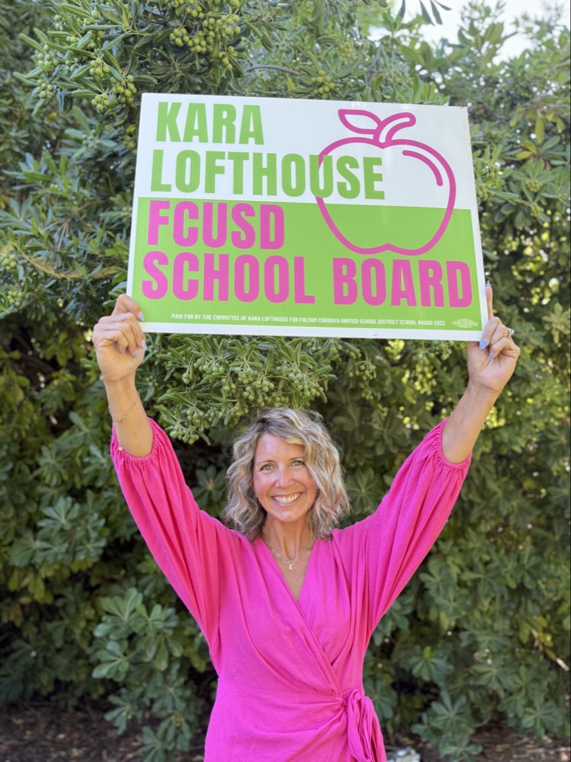 Kara holding her campaign sign overhead